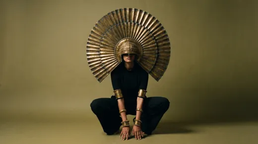 Gamini costume test: plain black clothing with a large gold sunburst headdress